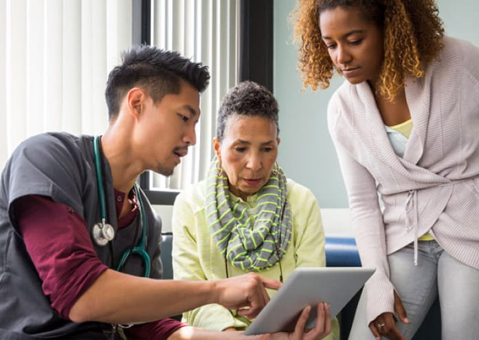 male medical worker going over results with a black woman and her adult daughter