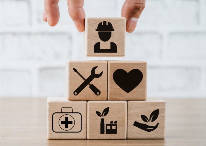 stock image of a hand stacking wooden blocks with a different icon on each block